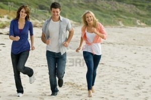 3441697-three-friends-running-along-a-sandy-beach-in-autumn